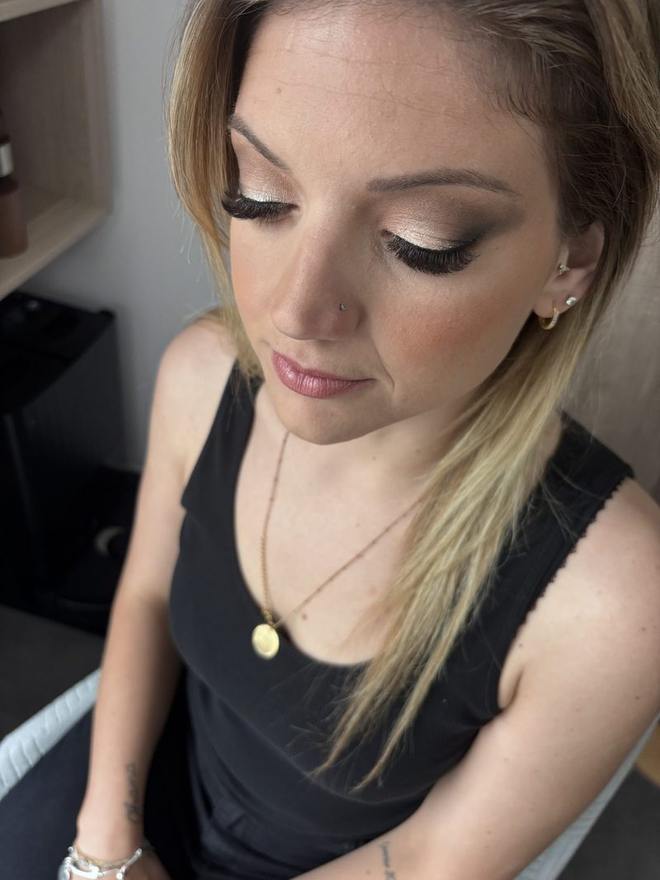Maquillage de soirée en plongée : smoky doré et brun, faux cils, bouche prune satinée
